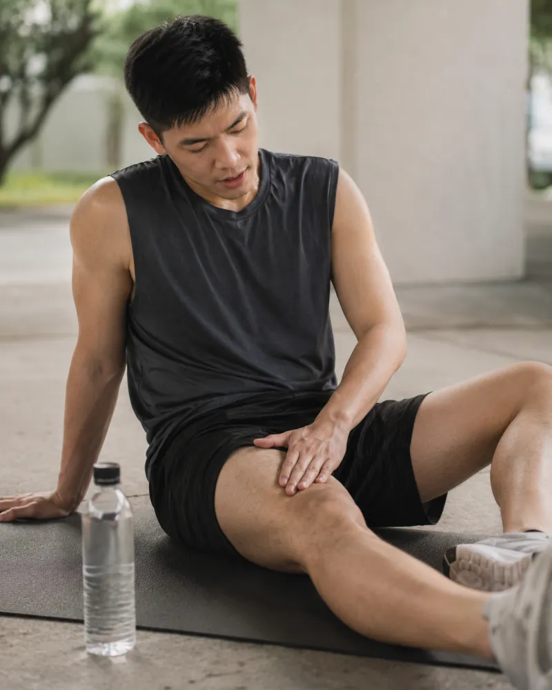 運動後肌肉痠痛：運動後坐地按壓大腿